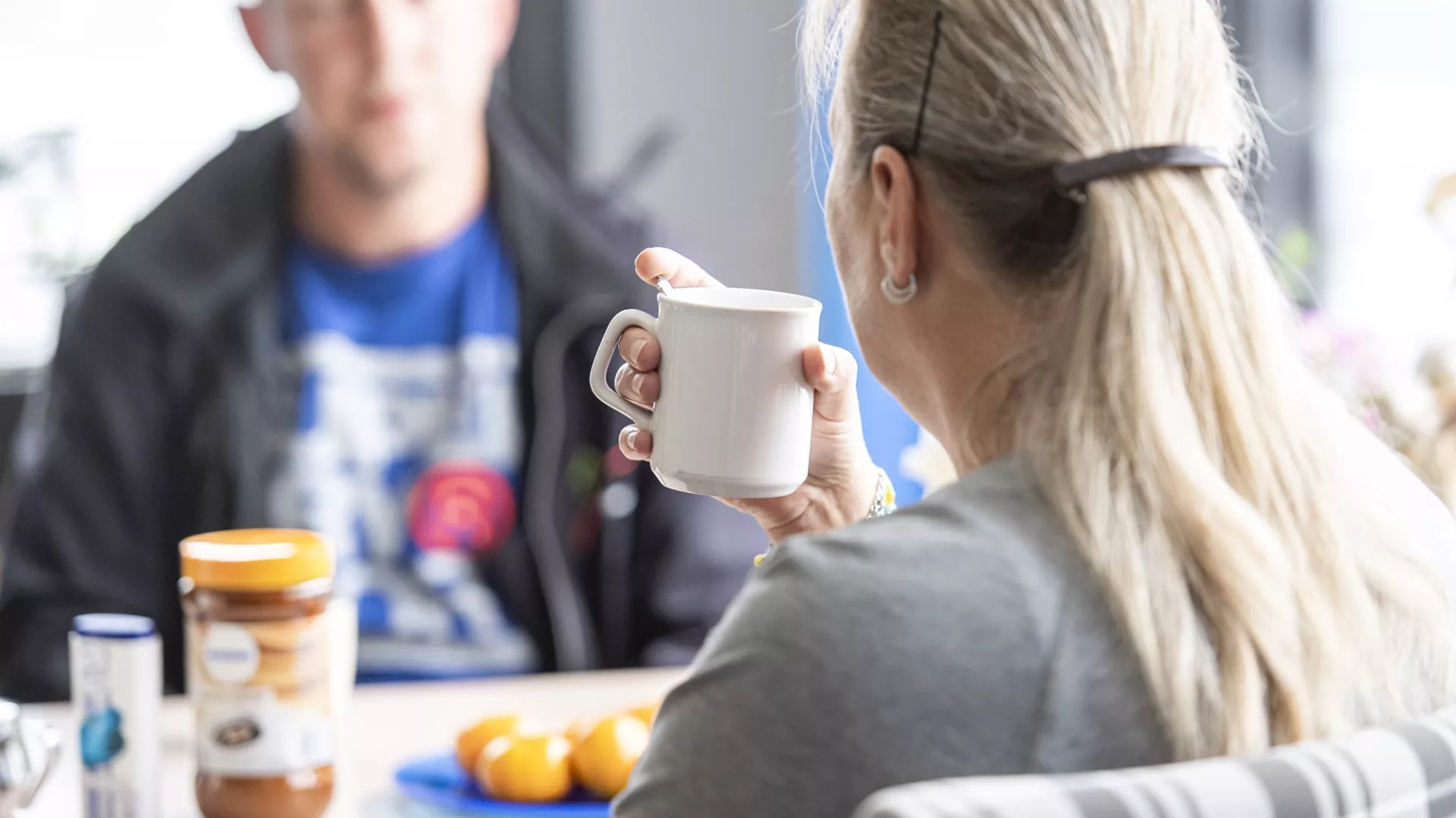 In gesprek aan de keukentafel met een kopje koffie