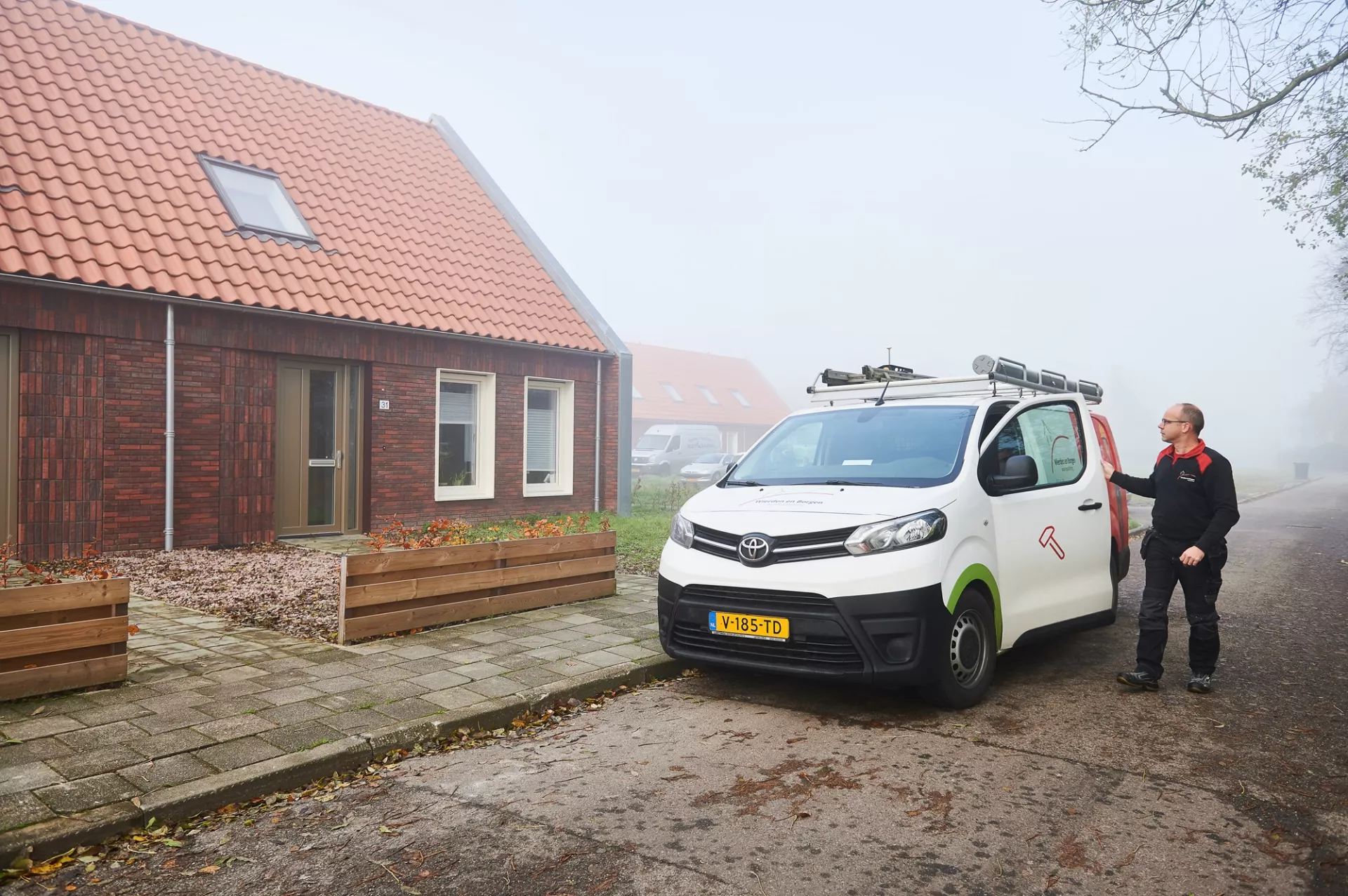 Vakman met bus bij woning