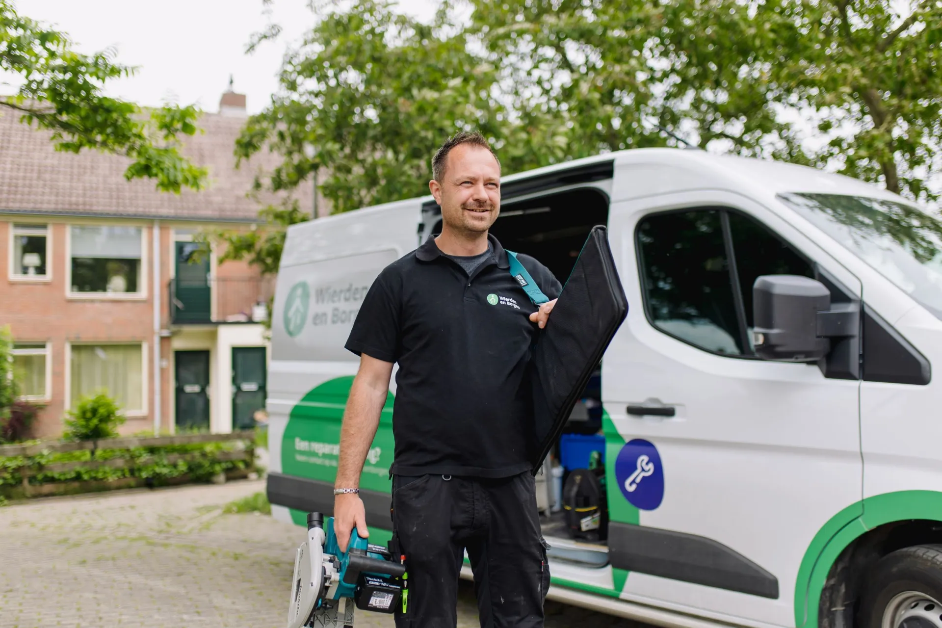 Vakman haalt gereedschap uit de bus