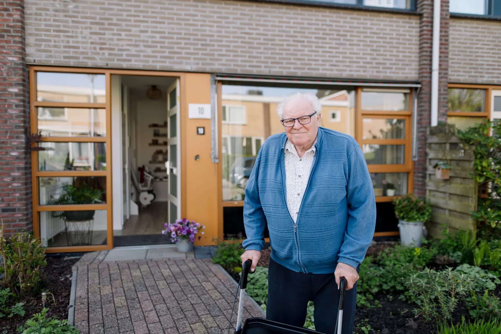 Huurder met rollator voor woning